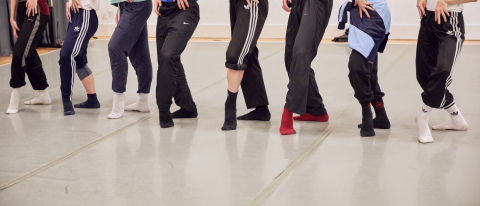 dancers legs standing on a white dance floor in socks