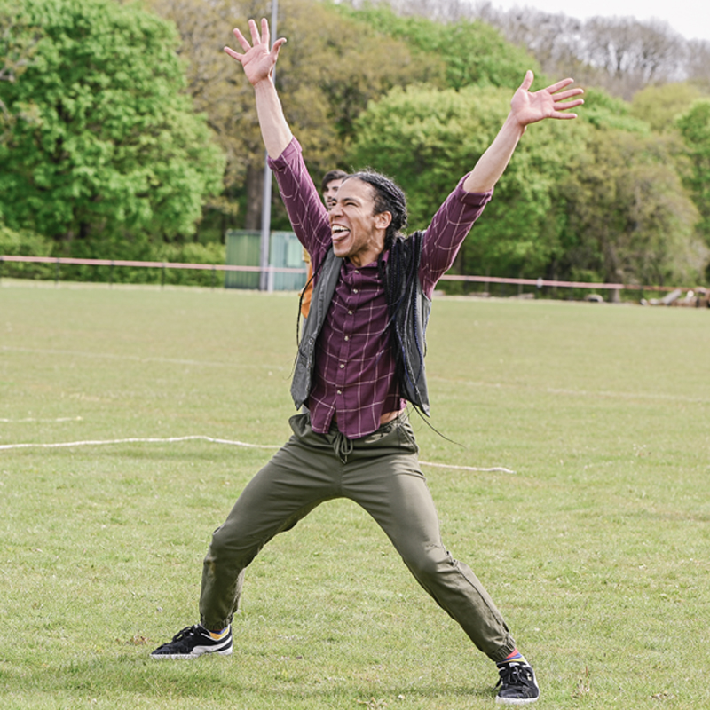 dancer Matt has his hands in the air grinning with his tongue out