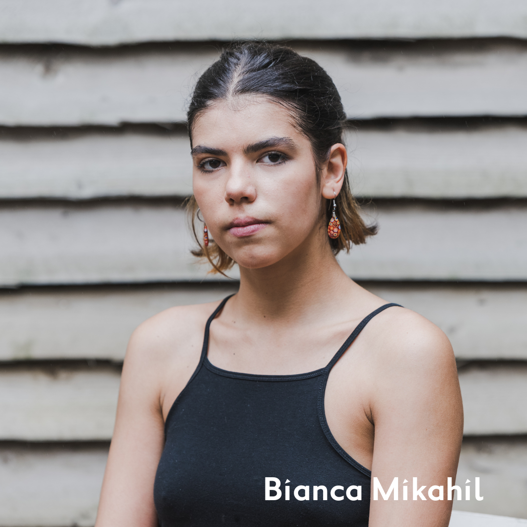 Bianca with slicked back hair and a black top