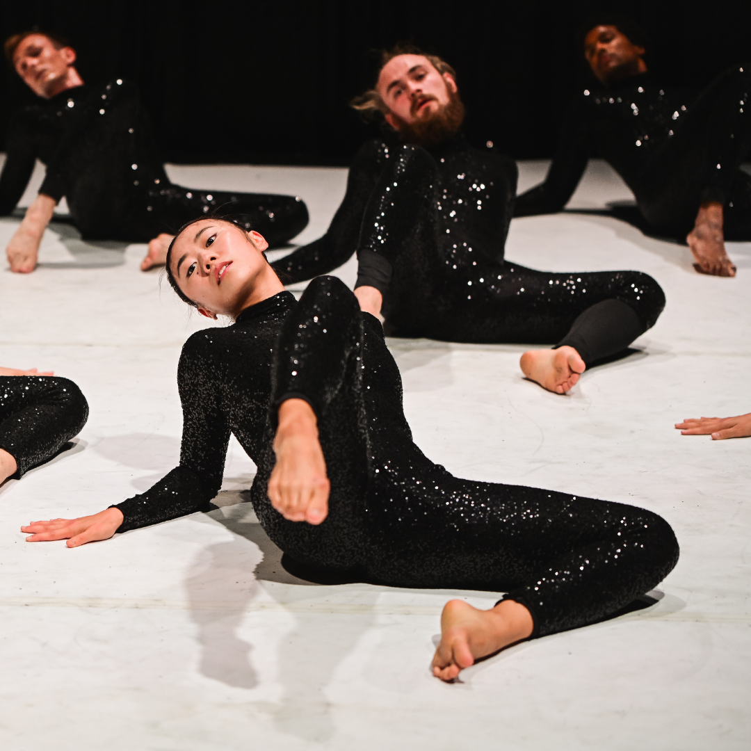 Waltz dancers lie back on the floor in black sequin costumes 