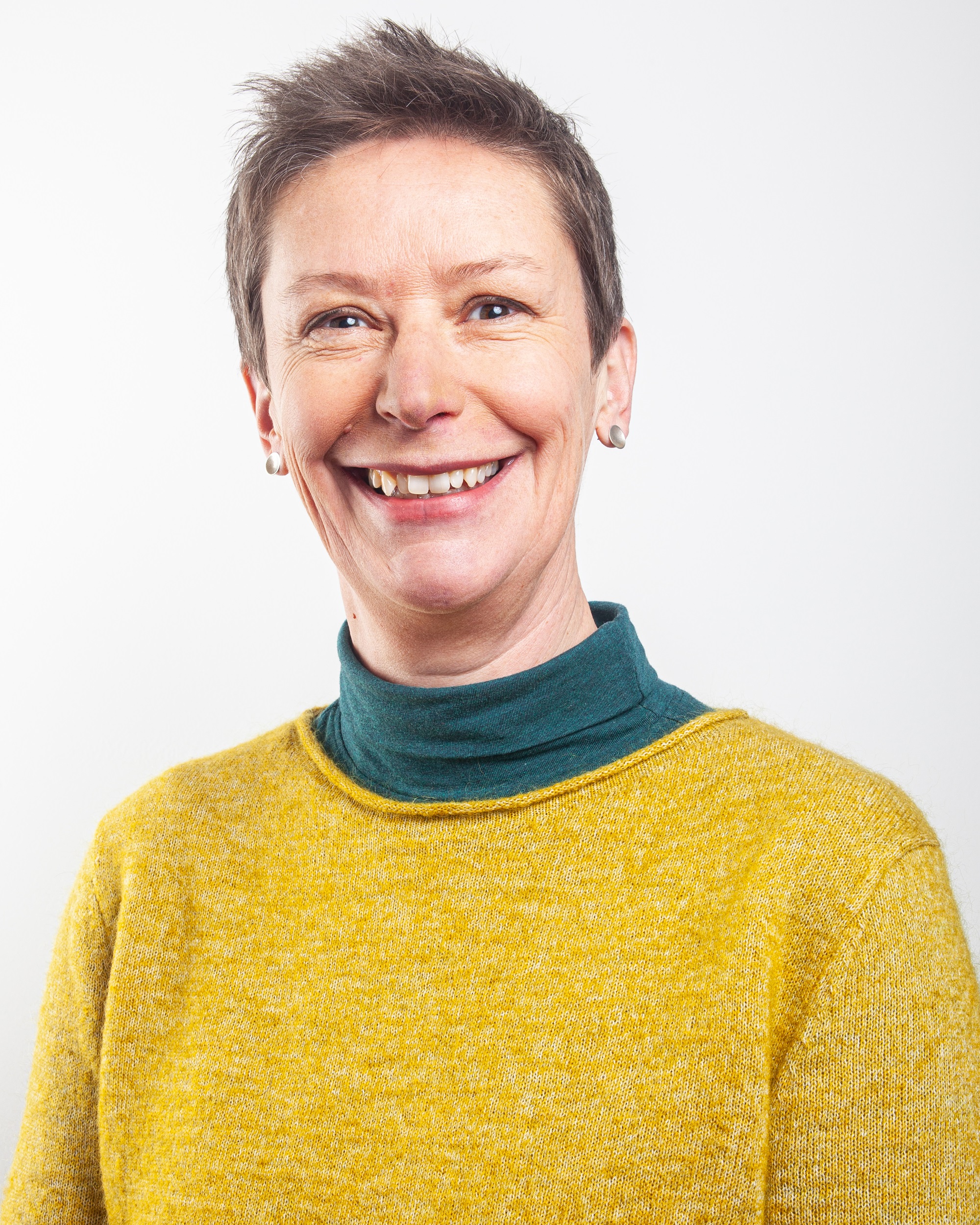 Michelle has short hair, a yellow jumper and a kind smile