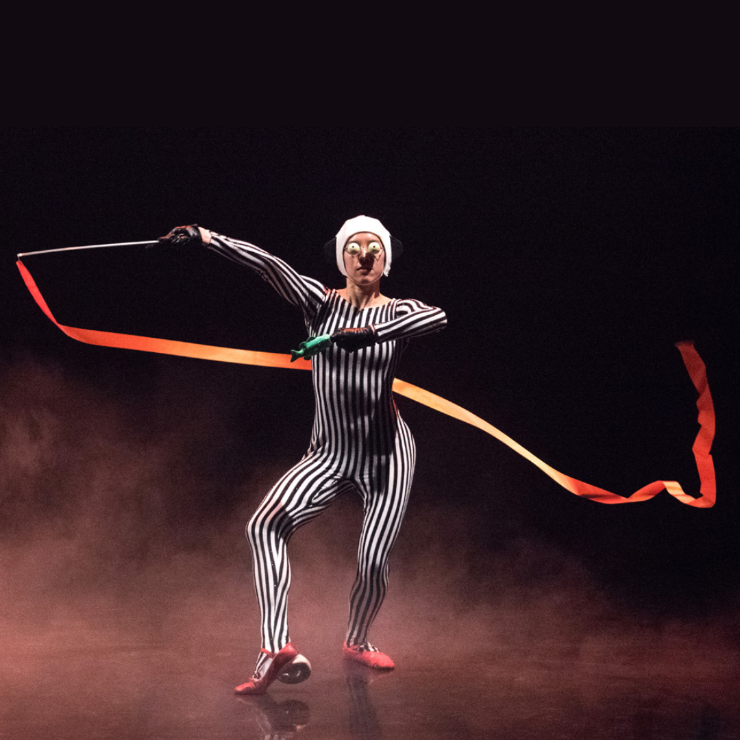 A dancer with a ribbon in a striped leotard