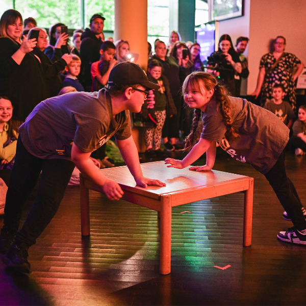 two children performing, dancing and smiling