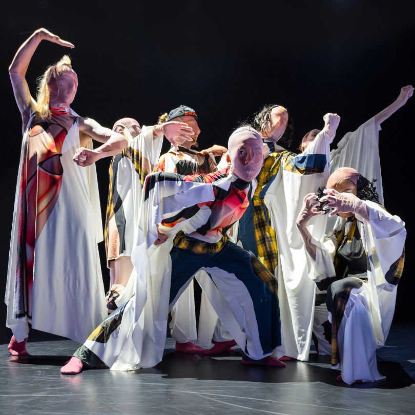 dancers in white costumes printed with 2d rendered outfits and strange masks that distort their features