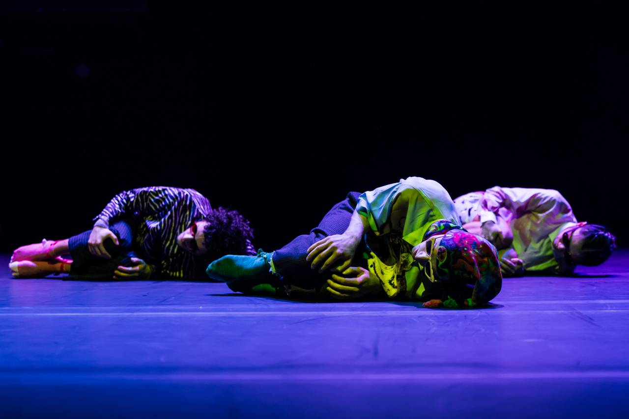 dancers lying on floor with knees to chest