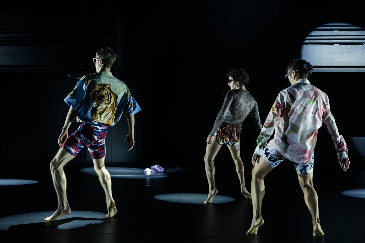dancers in loud shirts leaning backwards