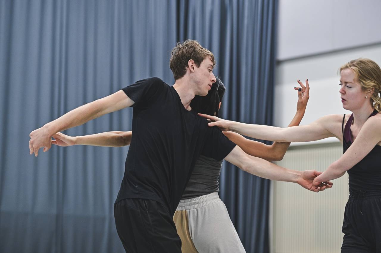 three dancers including sam practice dance in a bright studio