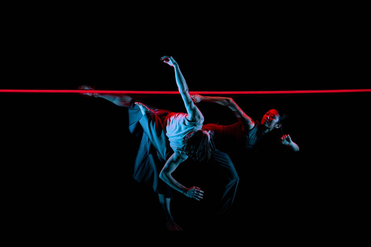 two dancers under a neon blue light 