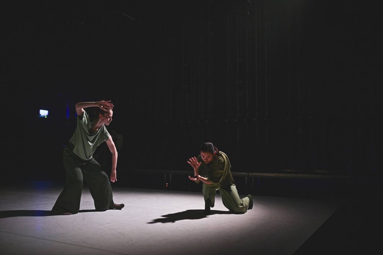 dancers in green costumes under stage lights