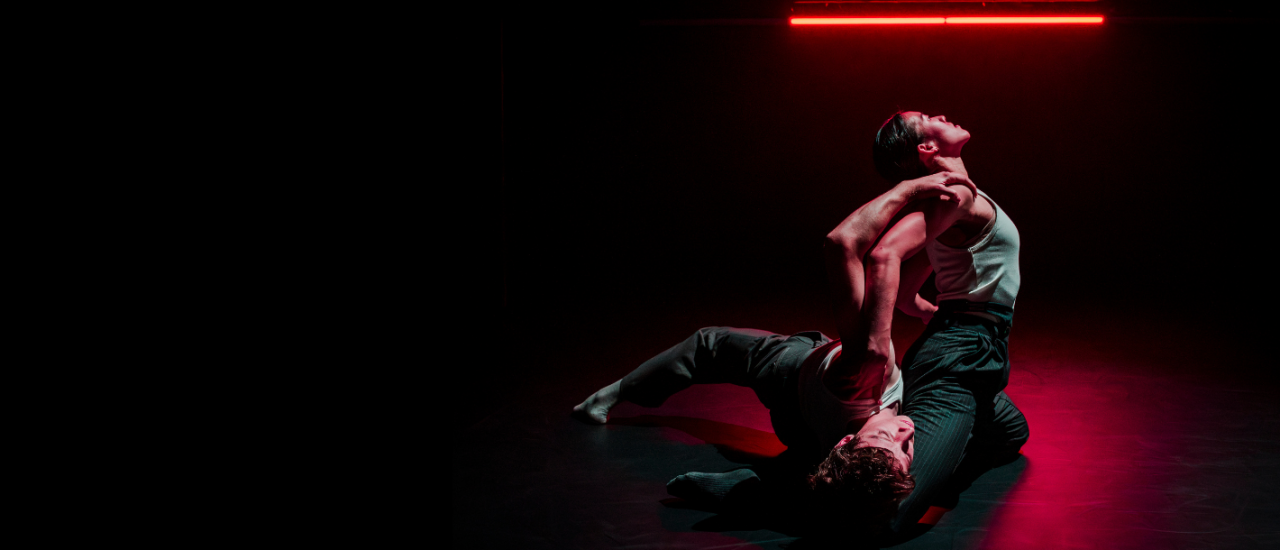 two dancers on the floor, one lying down, the other arching backwards over them