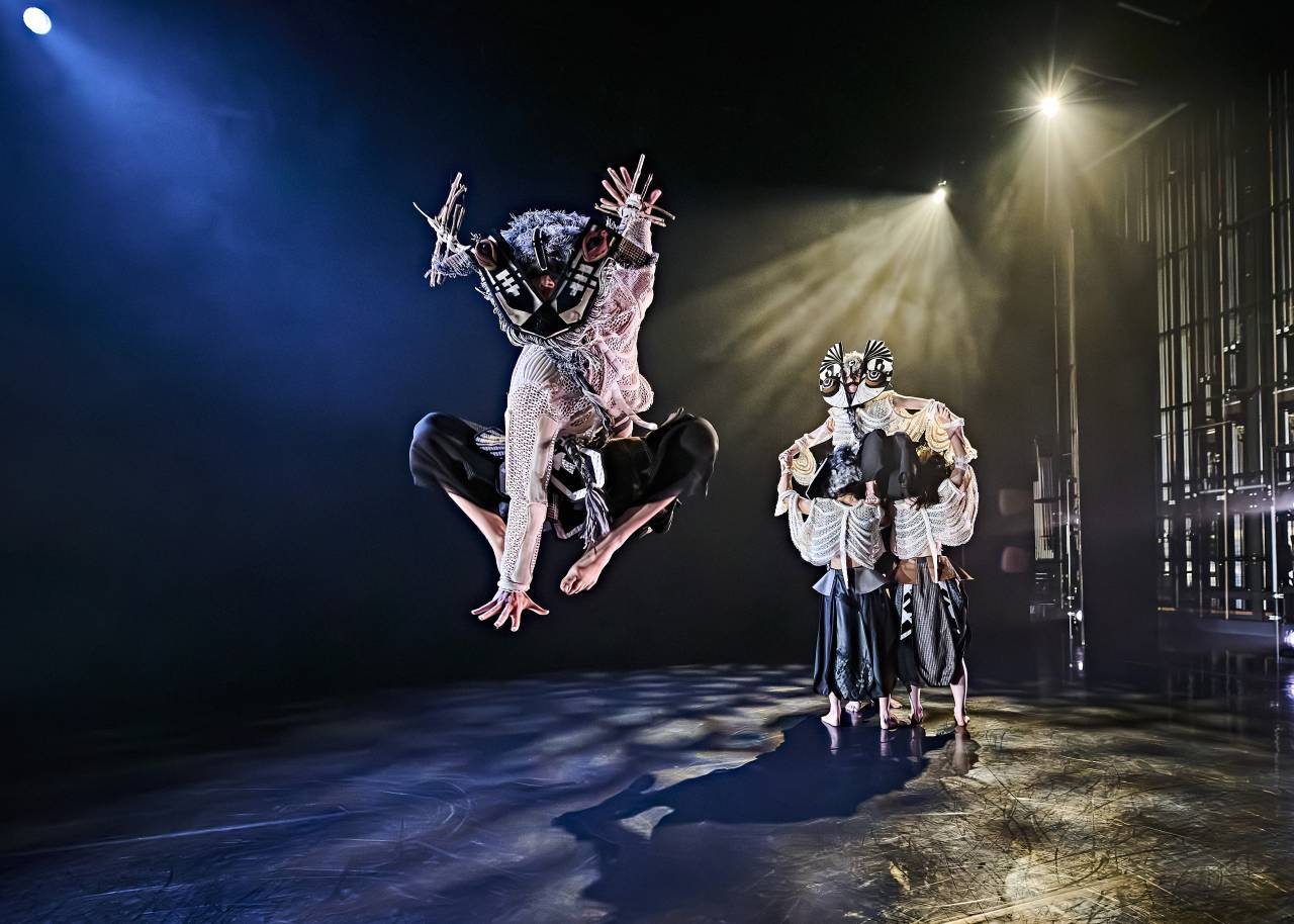 Pietro is dressed as a stag jumping high into the air as other dancers cluster behind him