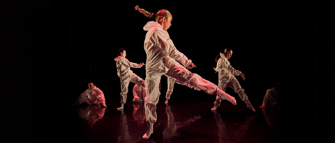 young dancers performing on stage in white paint overalls, hair flying