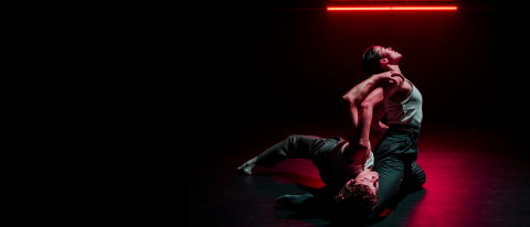 two dancers on the floor, one lying down, the other arching backwards over them