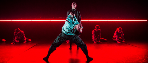 two dancers under dramatic red lighting 