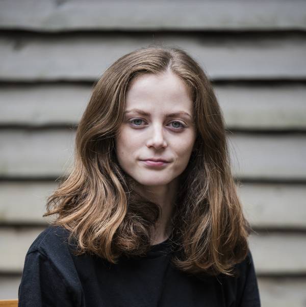 headshot of dancer Alys, she is white, has thick, straight, shoulder length brown hair and is wearing a black shirt